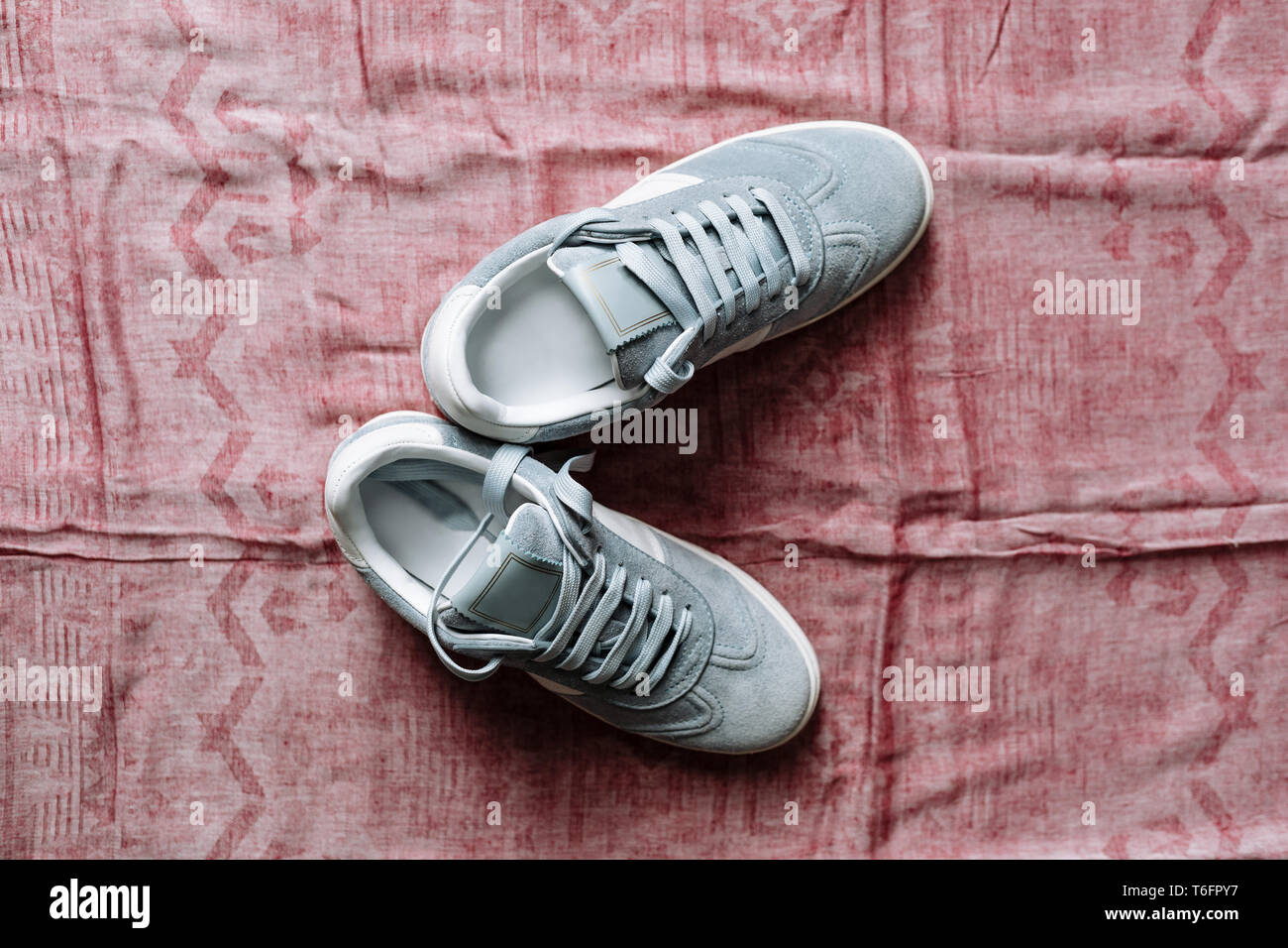 Un par de zapatillas de gamuza azul de moda en una suela blanca con acentos  de color blanco sobre un fondo de color rosa Fotografía de stock - Alamy