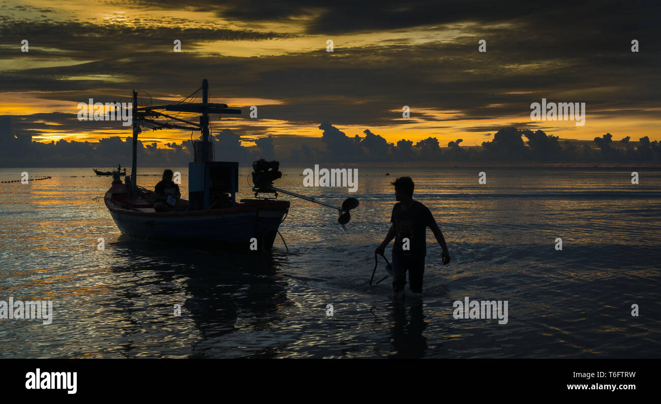 Pescador termine de trabajar después de la puesta del sol Foto de stock