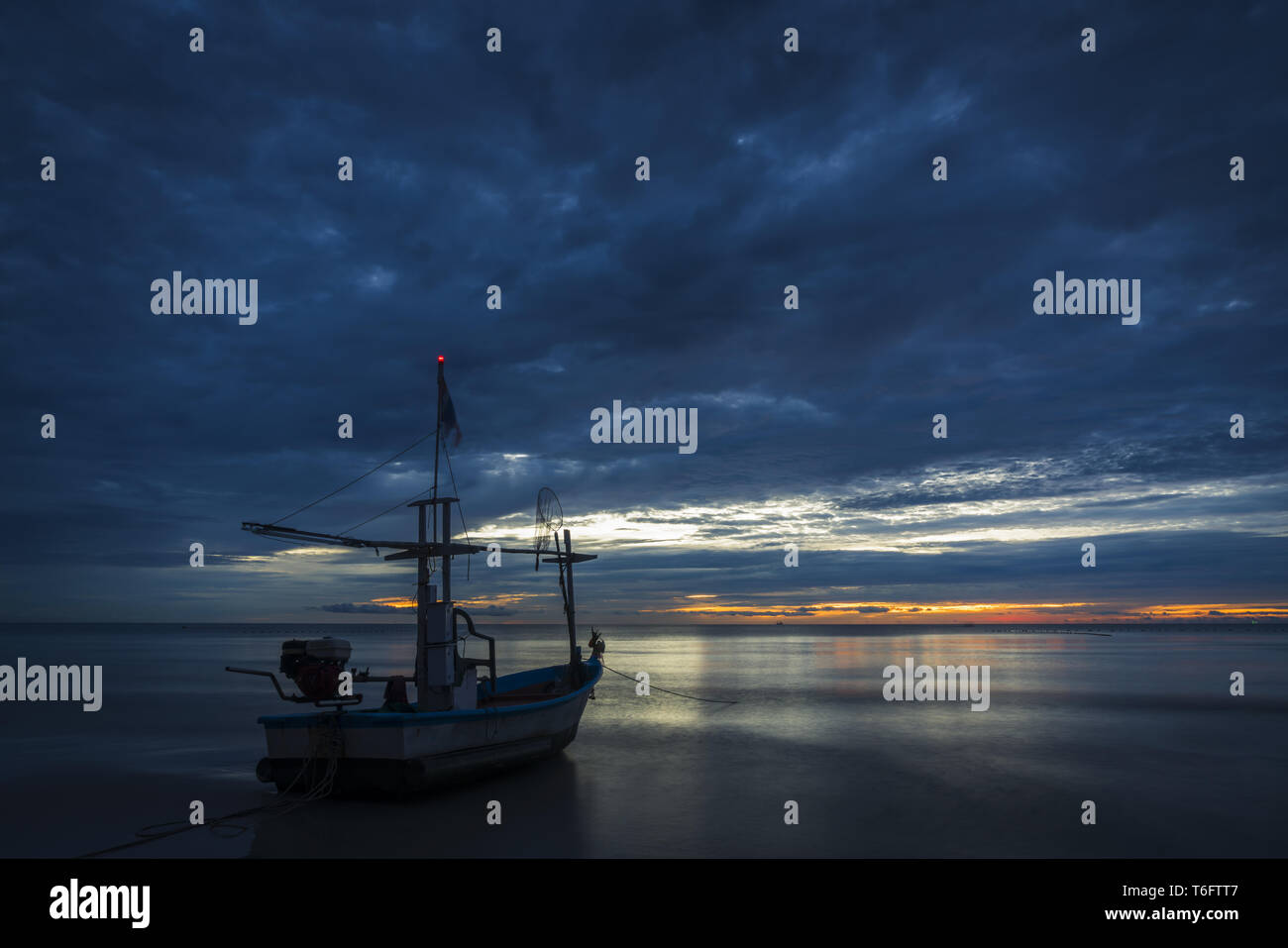 Descansar en un barco de peces para trabajar en amanecer Foto de stock