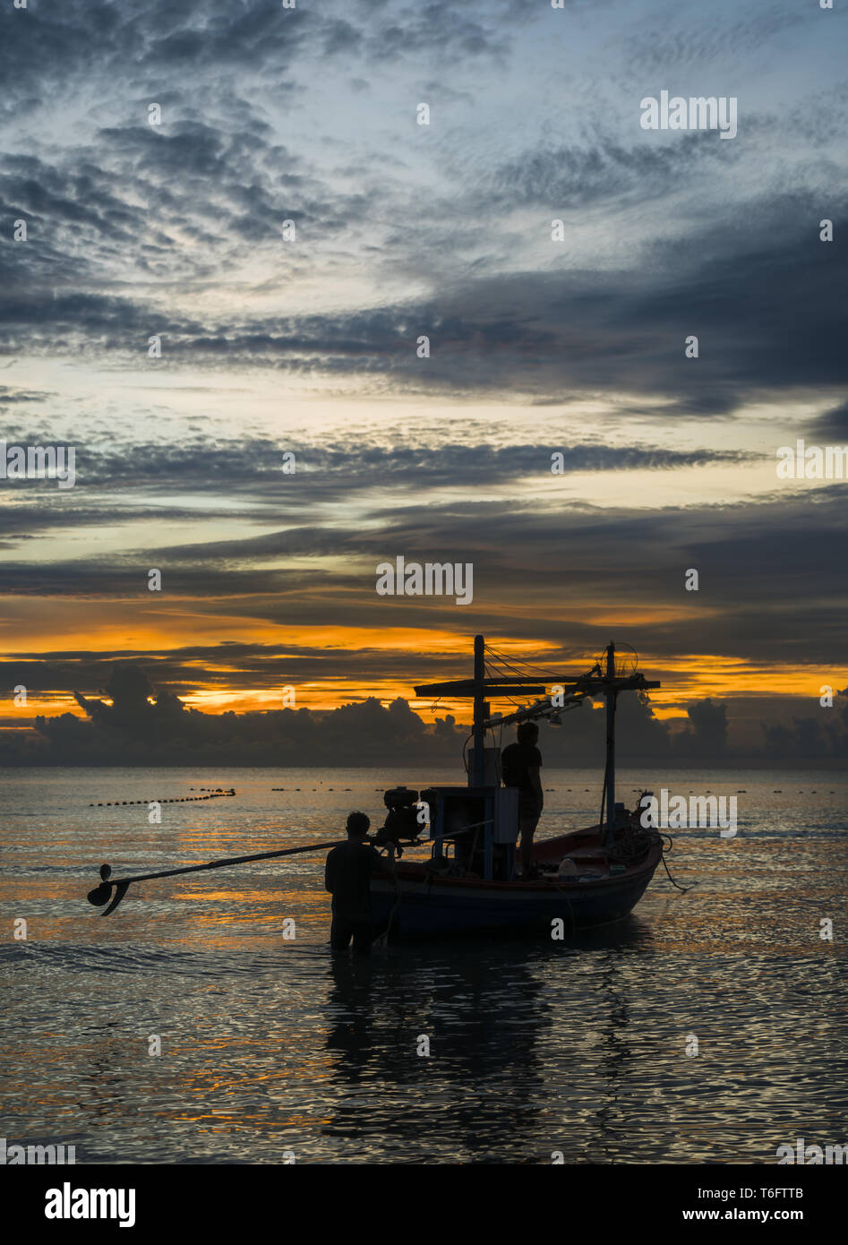 Un barco pesquero está listo para trabajar en amanecer Foto de stock