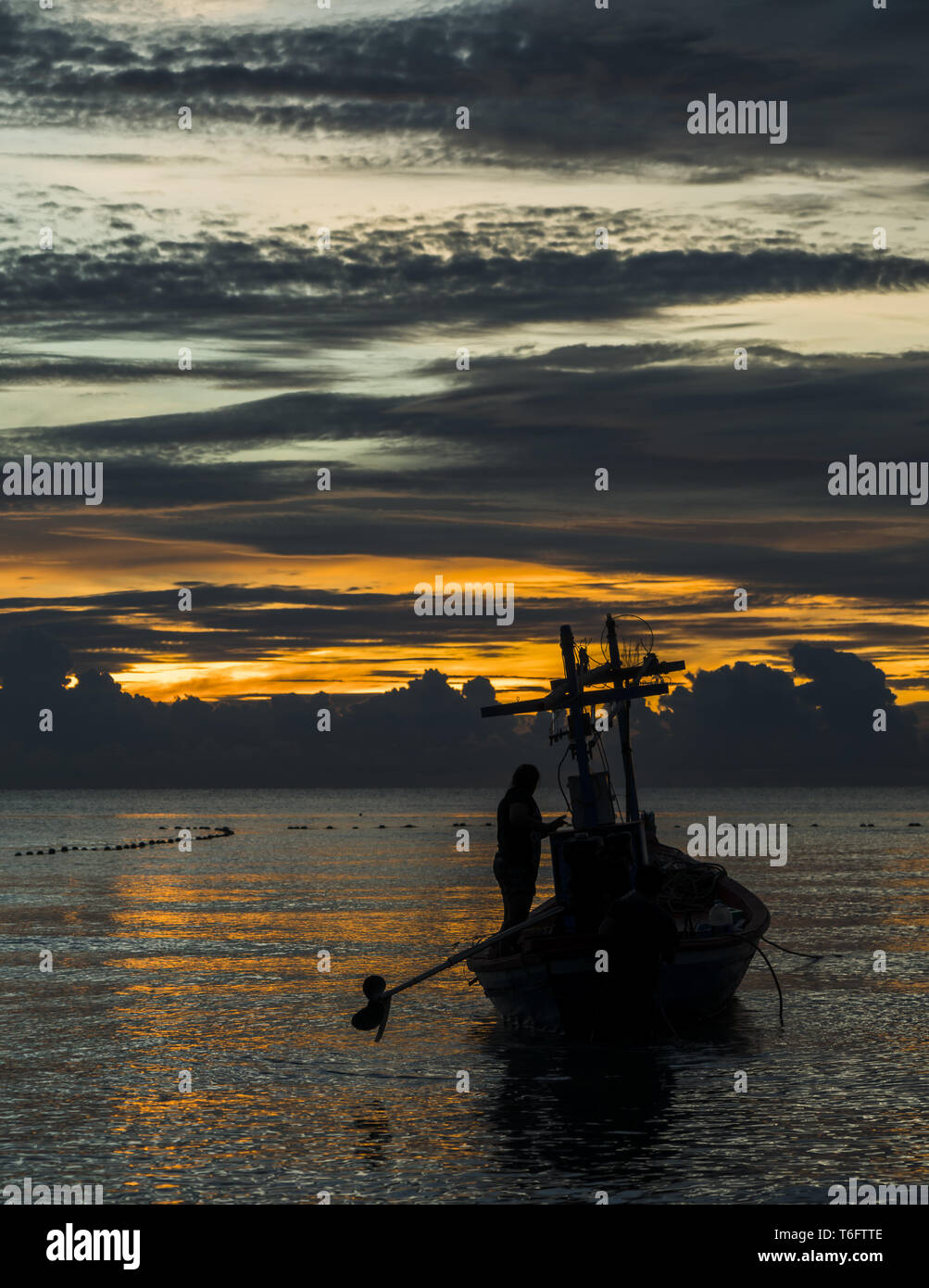 Un barco pesquero está listo para trabajar en amanecer Foto de stock
