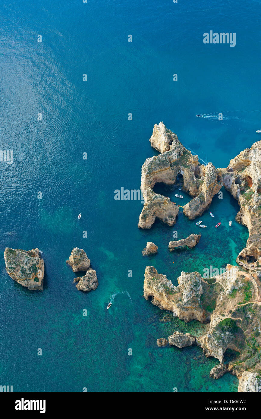 VISTA AÉREA. Paisaje costero profundamente erosionado con muchos sumideros, cuevas marinas y calas. Ponta da Piedade, Lagos, Algarve, Portugal. Foto de stock