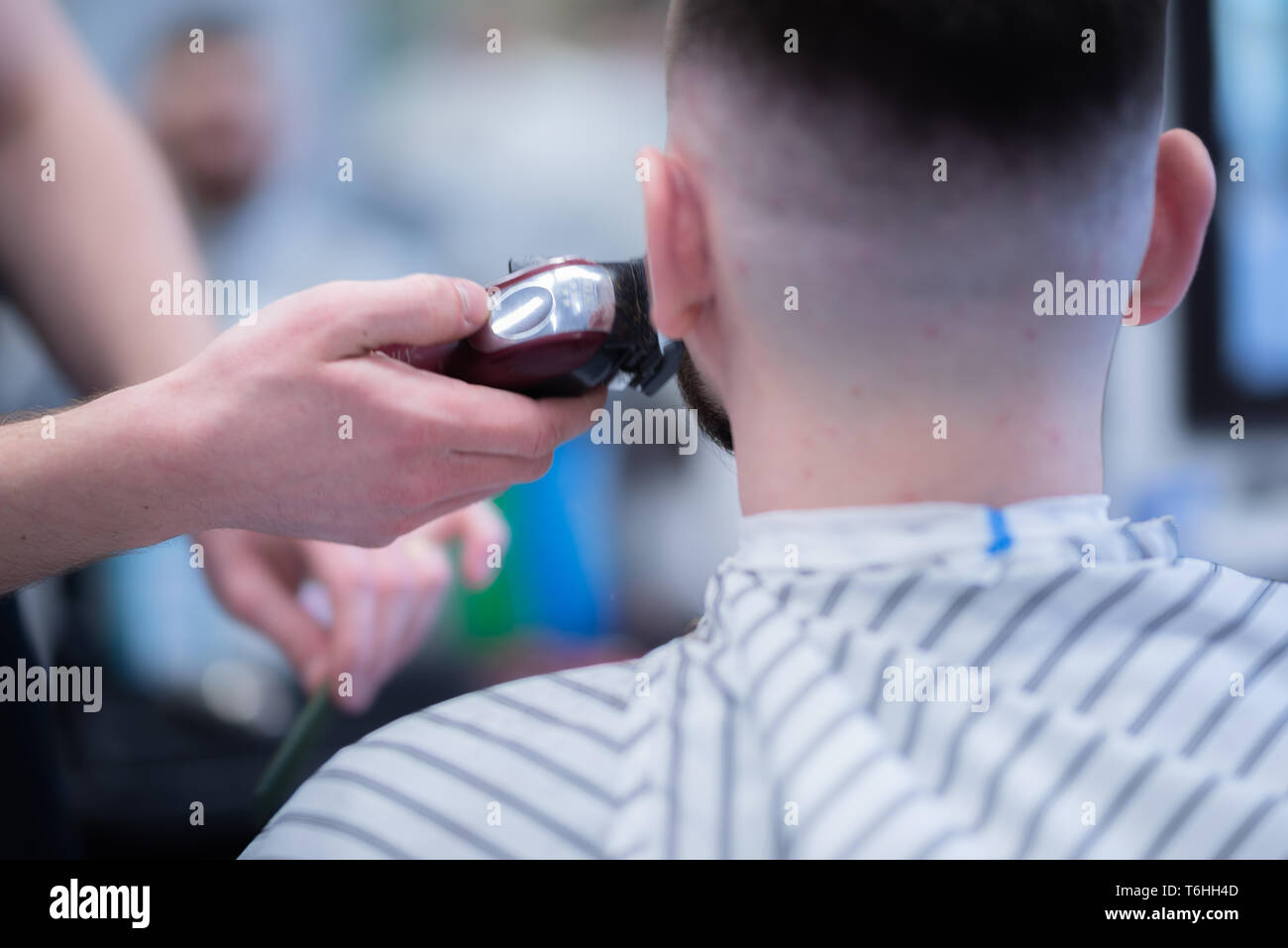 Hombre de corte de pelo en la peluquería. Afeitar una peligrosa de afeitar. Foto de stock