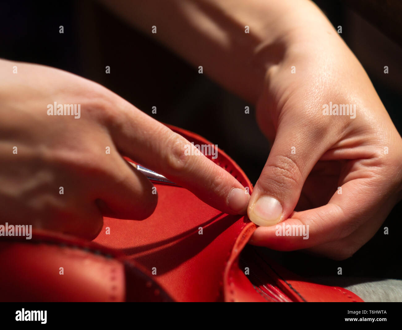 Detalle del trabajador que aplica pegamento a la suela de zapatos en una  línea de producción de la fábrica china de zapatos Fotografía de stock -  Alamy