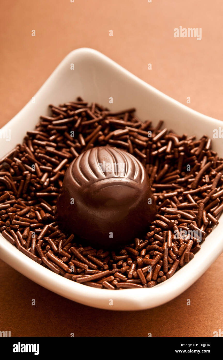 Bombón de chocolate en una cama de chocolate picado Foto de stock
