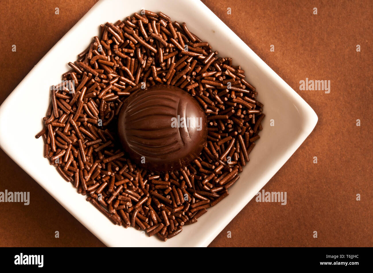 Bombón de chocolate en una cama de chocolate picado Foto de stock
