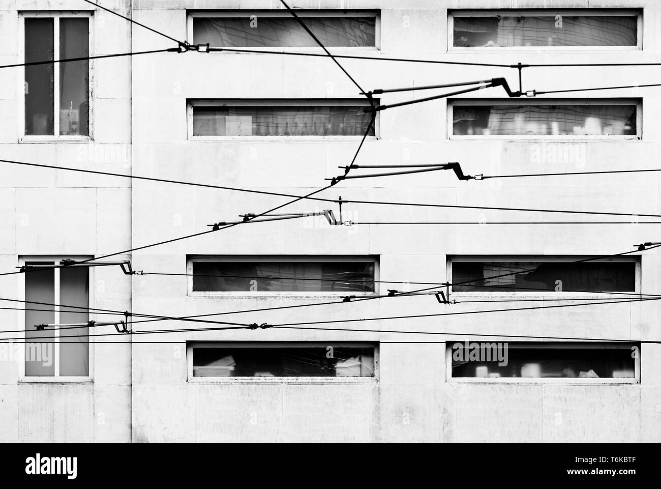 Cables eléctricos aéreos de tranvía delante de la fachada de un edificio, Milan, Italia. Foto de stock