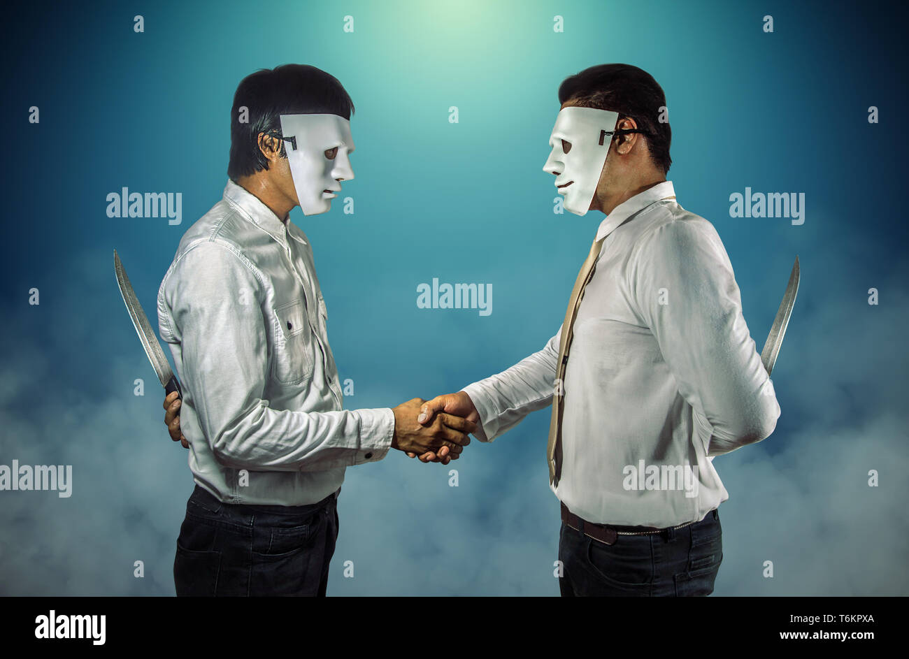 Dos empresarios enmascarados un apretón de manos y sosteniendo cuchillos a sus espaldas. Foto de stock