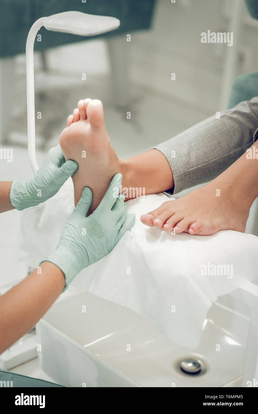 Master en belleza calificados guantes rozando las piernas de su cliente  Fotografía de stock - Alamy