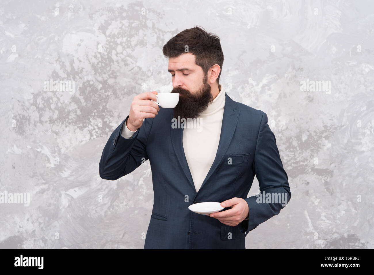 Modelo de moda masculina. Empresario maduro. Elegante hombre con barba  beber café. Brutal hipster barbudo en traje formal. La vida moderna. Sastre  o diseñador de moda. Negocios sin prisas. Oficina de rutina