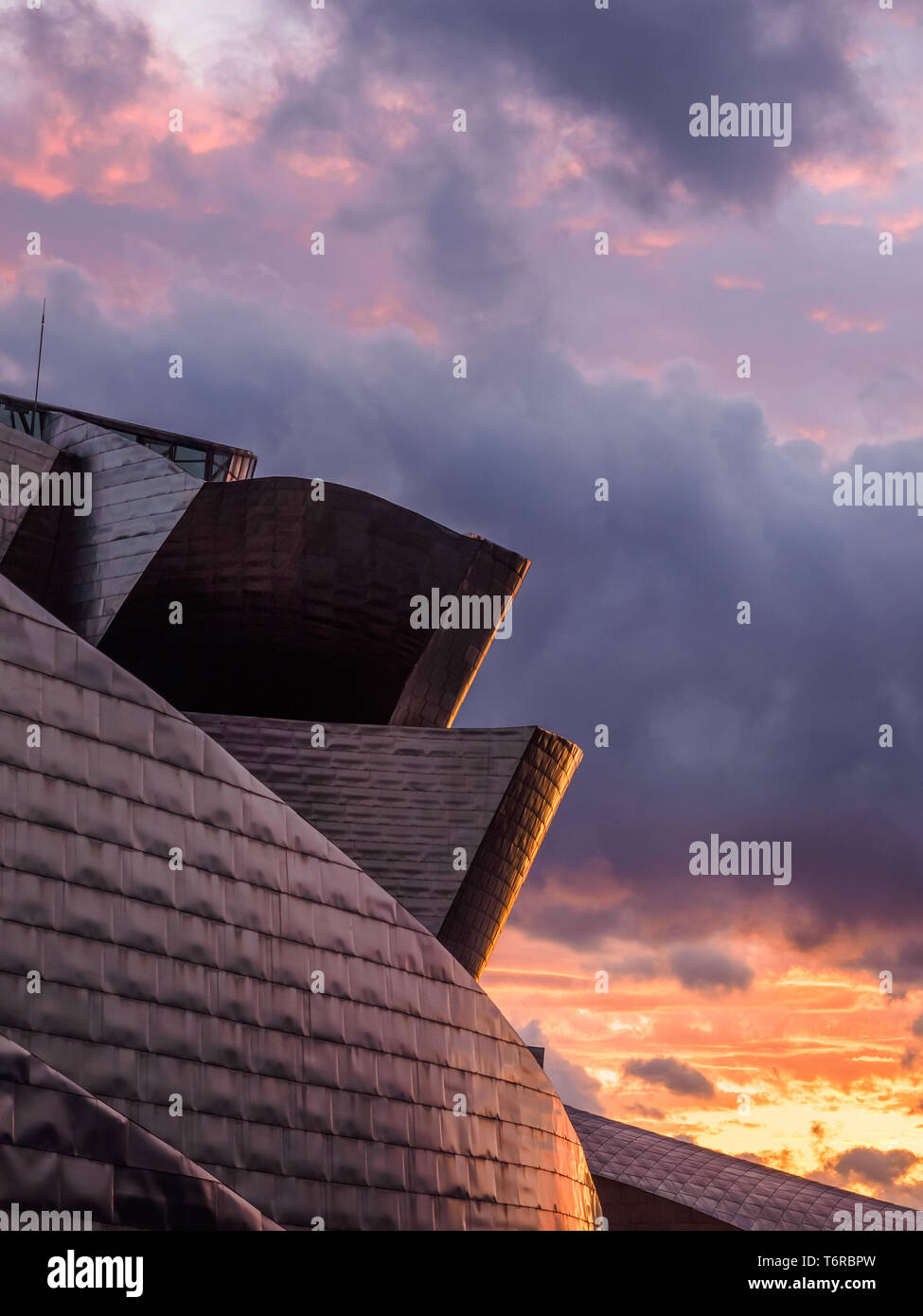 Cerca de Museo Guggenheim Bilbao riverside durante la puesta de sol, vista desde el puente de la salve Foto de stock