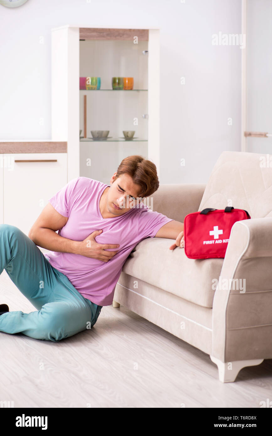 Hombre enfermo en casa con kit de primeros auxilios Foto de stock