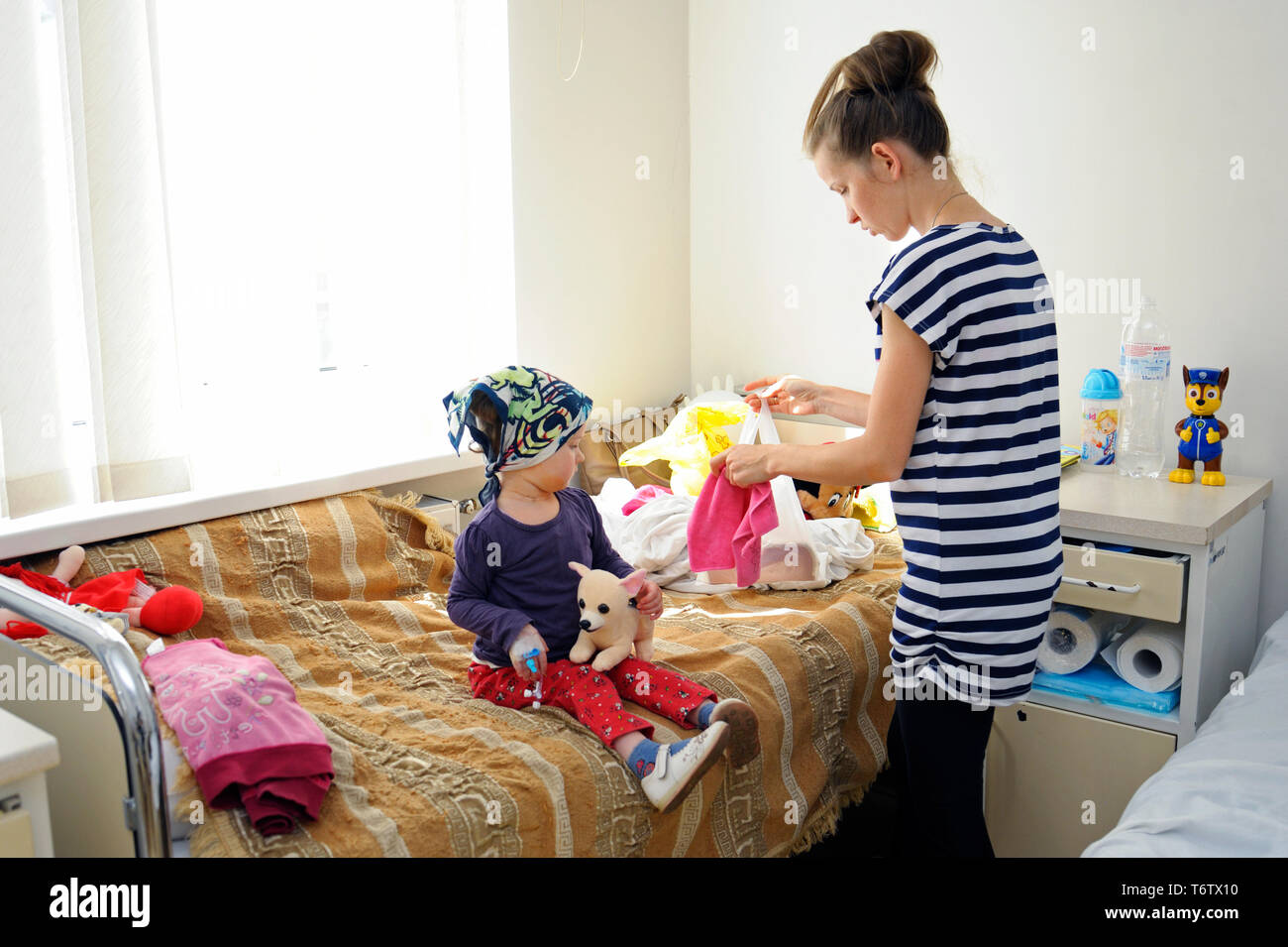 Mujer de cambiarse de ropa para bebé niña sentada en una cama de la  habitación de un hospital. Mayo 18,2018. Kiev, Ucrania Fotografía de stock  - Alamy
