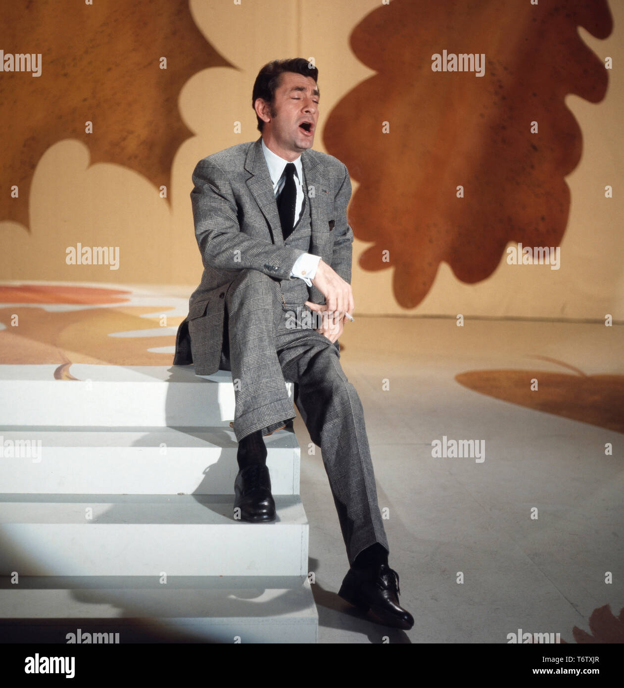 Der französische Modedesigner Schauspieler und Sänger, Jean-Claude Pascal singend auf einer Bühne, Deutschland Ende 1960er. El modisto francés, actor y cantante Jean-Claude Pascal cantando en un escenario, Alemania 1960. Foto de stock