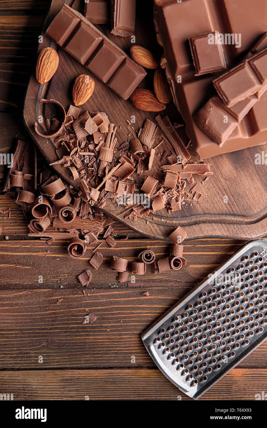 Trozos de chocolate con almendras y rallador sobre mesa de madera  Fotografía de stock - Alamy
