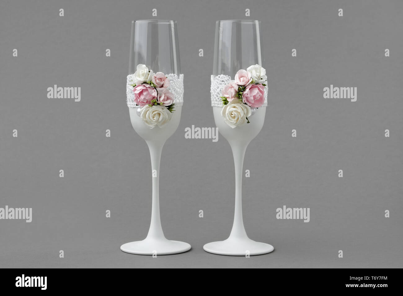 Dos copas de vino de bodas decoradas con encajes y rosas sobre fondo gris  Fotografía de stock - Alamy