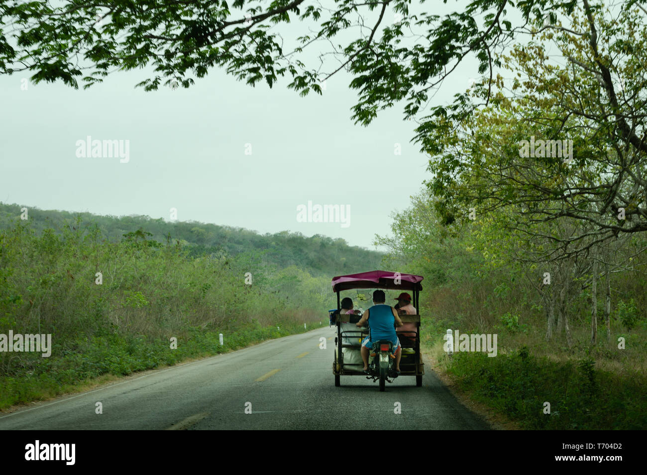 La familia maya tradicional montando una moto taxi en Yucatán, México