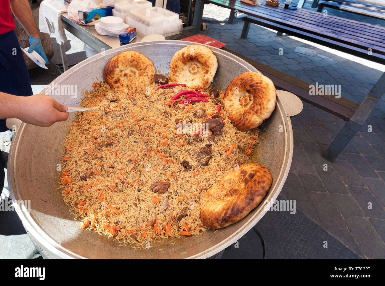 https://c8.alamy.com/compes/t70gpt/sabroso-pilaf-cocido-a-la-parrilla-en-la-calle-en-un-caldero-grande-t70gpt.jpg