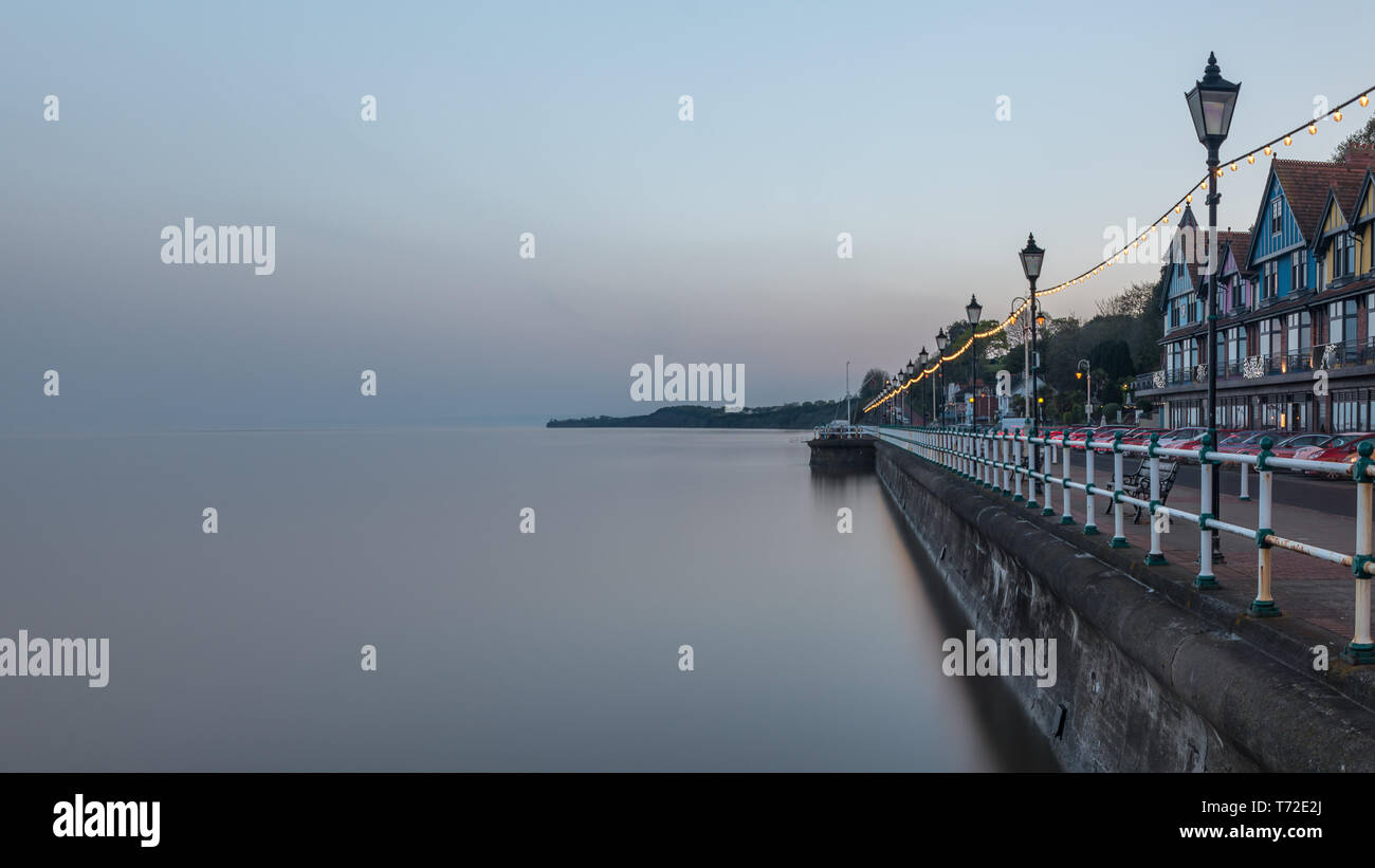 Penarth paseo marítimo, cerca de Cardiff en Gales del Sur de la costa. Es de noche y la marea. El mar es suave debido a una velocidad de obturación lenta. Foto de stock