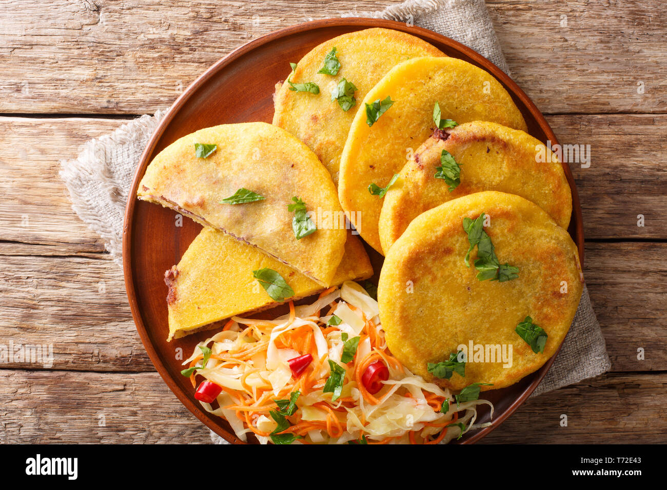 Vegetarianas deliciosas Pupusas frito servido con coleslaw cerca en una placa en la tabla superior horizontal vista desde arriba Foto de stock
