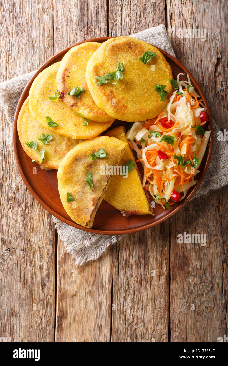 Se sirve con curtido pupusa salvadoreña closeup en una placa. Vista superior de la vertical desde arriba Foto de stock