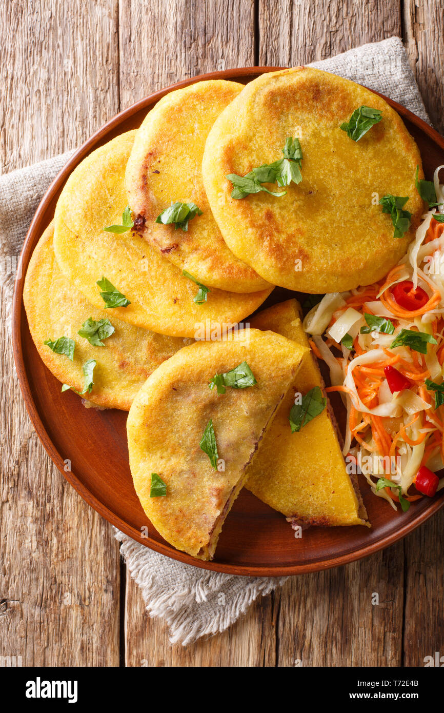 Vegetarianas deliciosas Pupusas frito servido con coleslaw cerca en una placa en la tabla. Vista superior de la vertical desde arriba Foto de stock