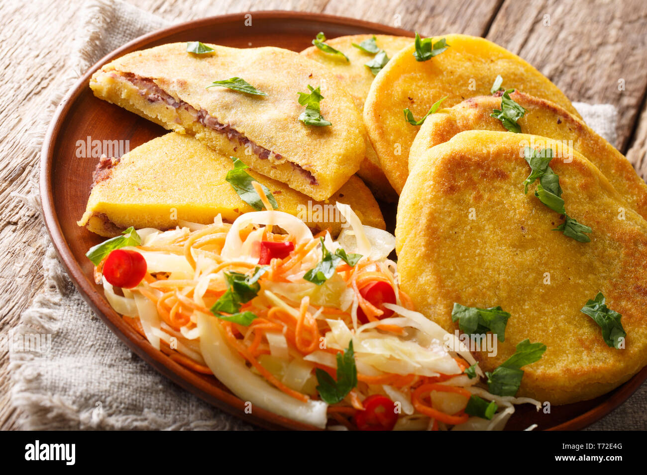 Comida salvadoreña Pupusas frito servido con coleslaw cerca en una placa horizontal sobre la mesa. Foto de stock