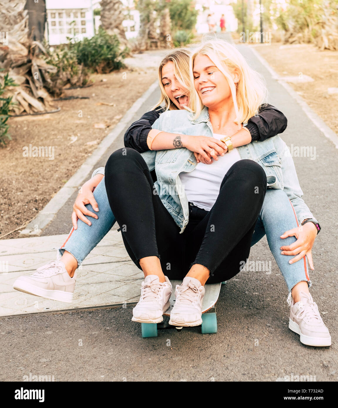 Los jóvenes feliz pareja de amigos niñas divertirse juntos montando un monopatín en el camino para el ocio al aire libre actividades divertidas - amistad y crazi Fotografía de stock - Alamy Los jóvenes feliz pareja de amigos niñas divertirse juntos montando un monopatín en el camino para el ocio al aire libre actividades divertidas - amistad y crazi Fotografía de stock - Alamy