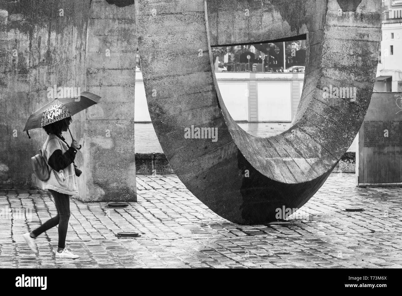 Una mujer sosteniendo un paraguas camina por una gran escultura sobre una  pasarela; Sevilla, España Fotografía de stock - Alamy