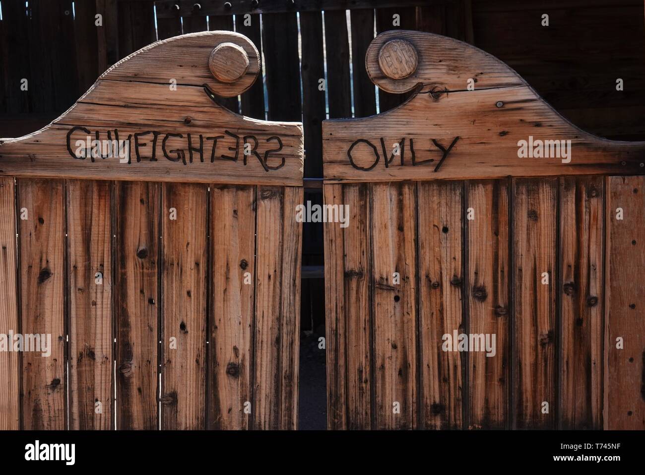 Las puertas de un saloon del salvaje oeste con una advertencia, gunfighters  solamente Fotografía de stock - Alamy