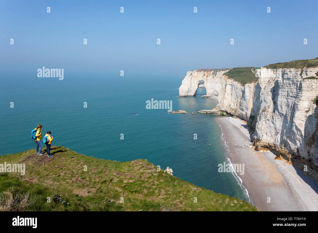Francia, Normandía: Madre e hijo de pie sobre el césped cubierto de roca acantilados por encima del arco de Playa Etretat Foto de stock