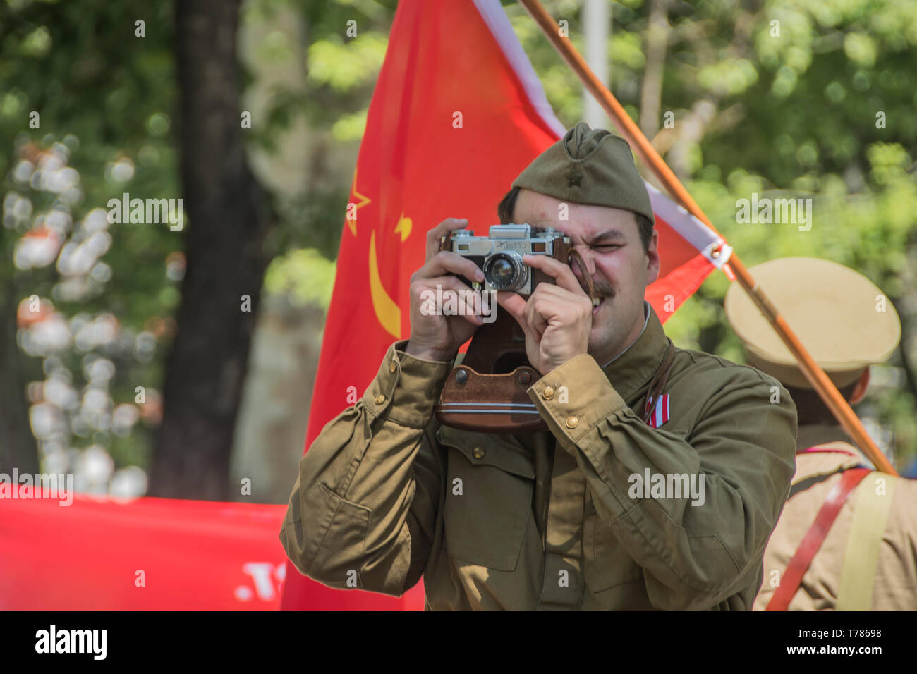 Un hombre que toma una foto con una cámara zenit ruso en la celebración de la Unión Soviética en su victoria en la segunda guerra mundial en la celebración en Madrid, España. Foto de stock