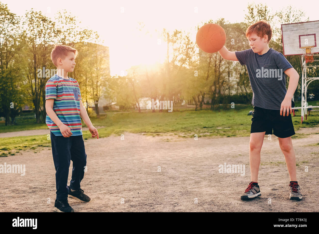 Dos jóvenes practicando sus habilidades de baloncesto en la cálida luz del  atardecer en un campo de deportes con un salto para evitar los movimientos  defensivos de la segunda Fotografía de stock -