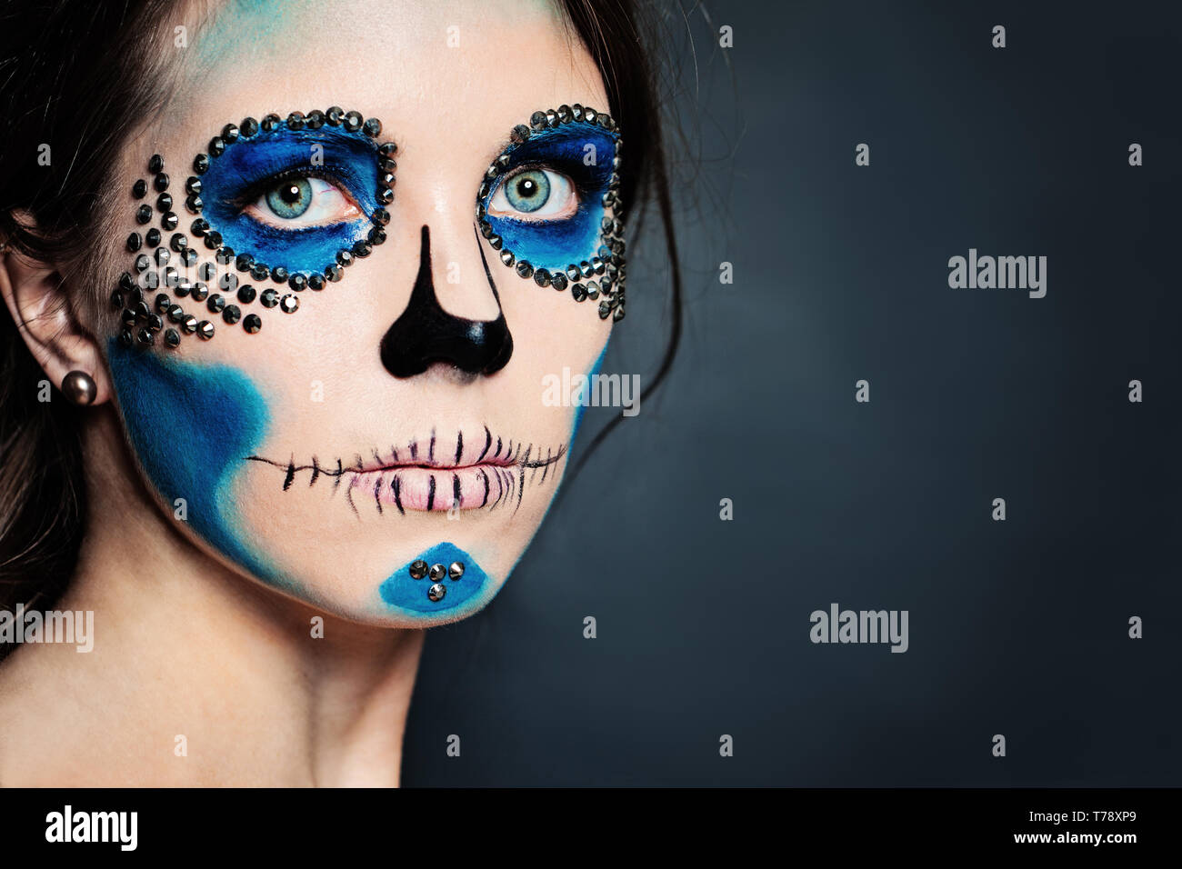 Carácter de Halloween maquillaje. Mujer con maquillaje de cráneo sobre  fondo azul Fotografía de stock - Alamy