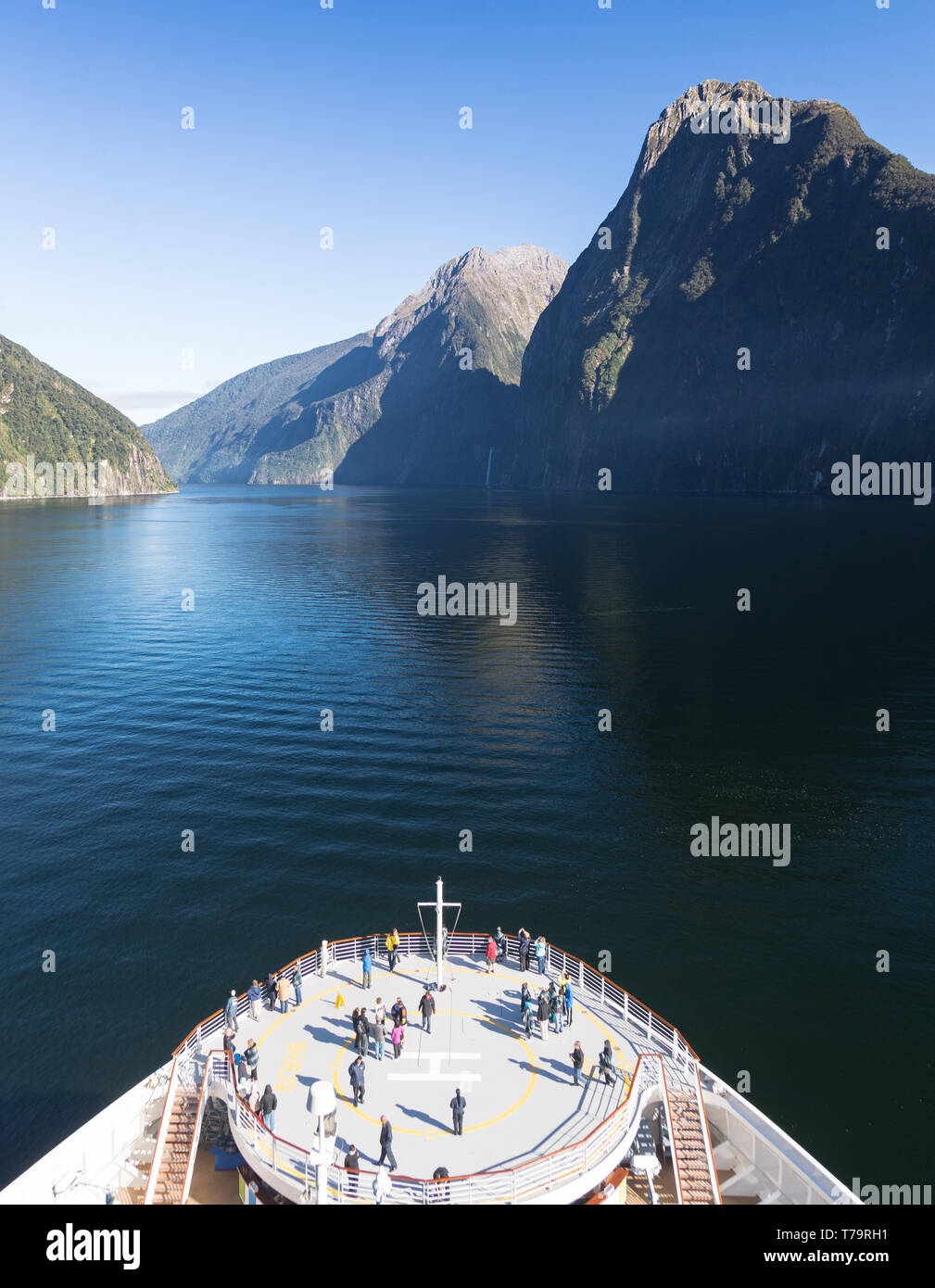 Fiordo de Milford Sound en Nueva Zelanda con pasajeros en un crucero de pie en la proa de la embarcación y admirar el magnífico paisaje Foto de stock