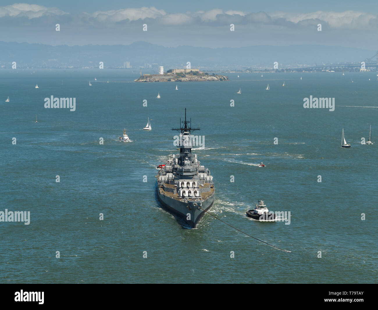 Vista del puerto de San Francisco con cientos de veleros salpicando agua a vela, una marina de la segunda guerra mundial, el acorazado y remolcadores dejando bay Foto de stock