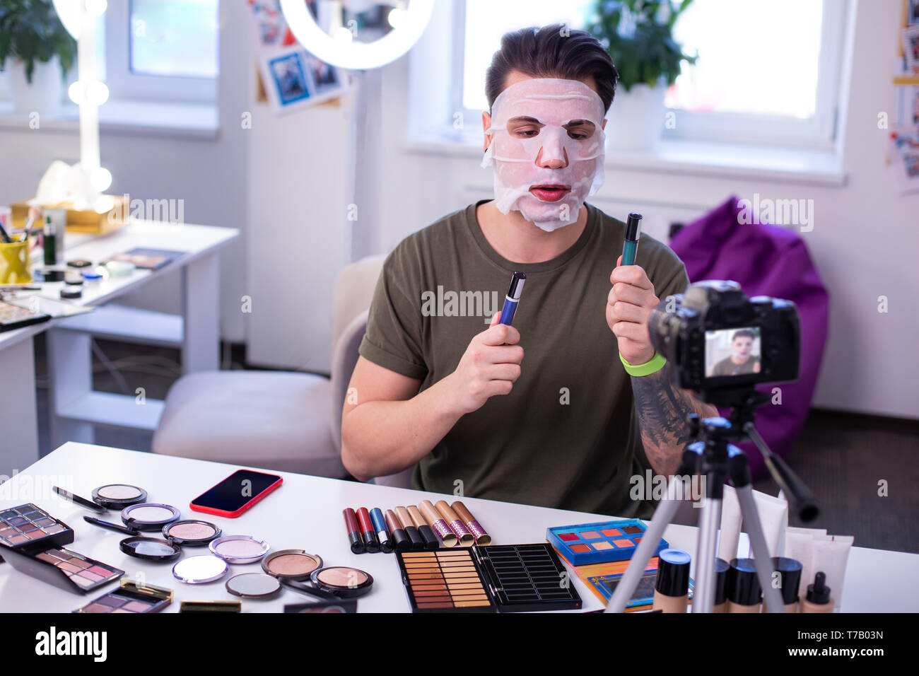 Grave Hombre De Pelo Corto Camiseta Verde Comparar Diferentes Productos De Maquillaje Fotografia De Stock Alamy