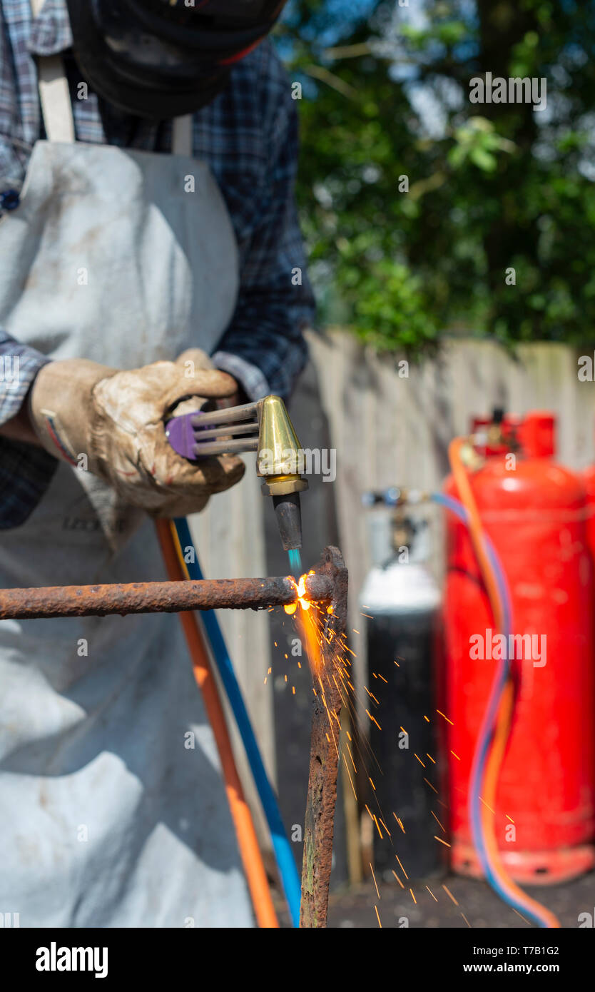 El hombre cortando el hierro forjado con una antorcha de gas Foto de stock
