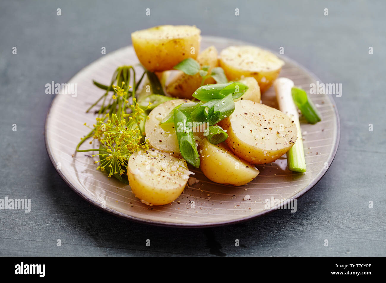 Ensalada de patatas con oniens dild,primavera, aceite de oliva, sal y pimienta. Foto de stock