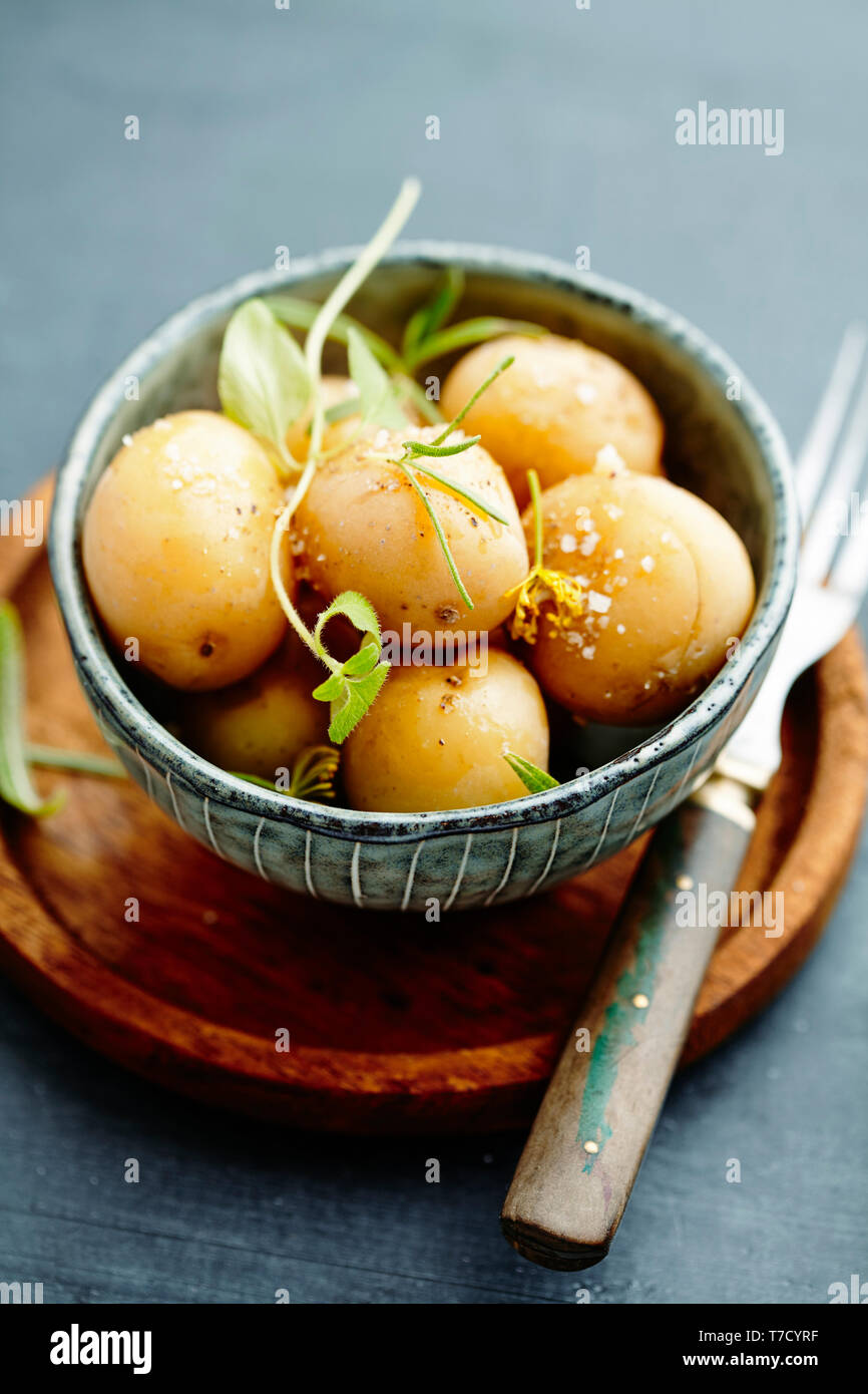 Bebé patatas hervidas con hierbas, aceite de oliva y sal marina Foto de stock