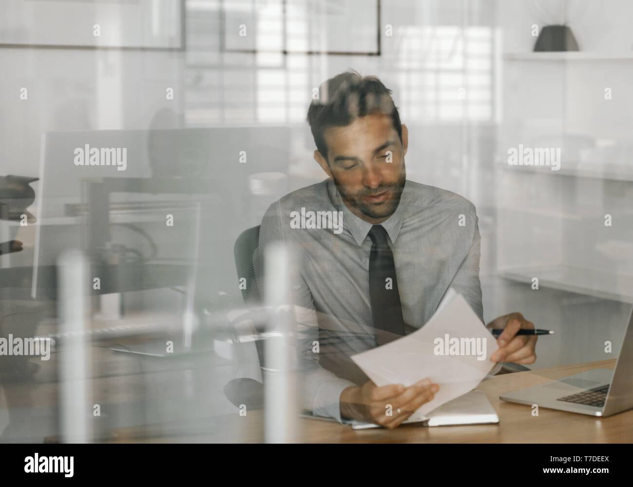 Contenido empresario sentado en el trabajo de revisar ideas por escrito Foto de stock