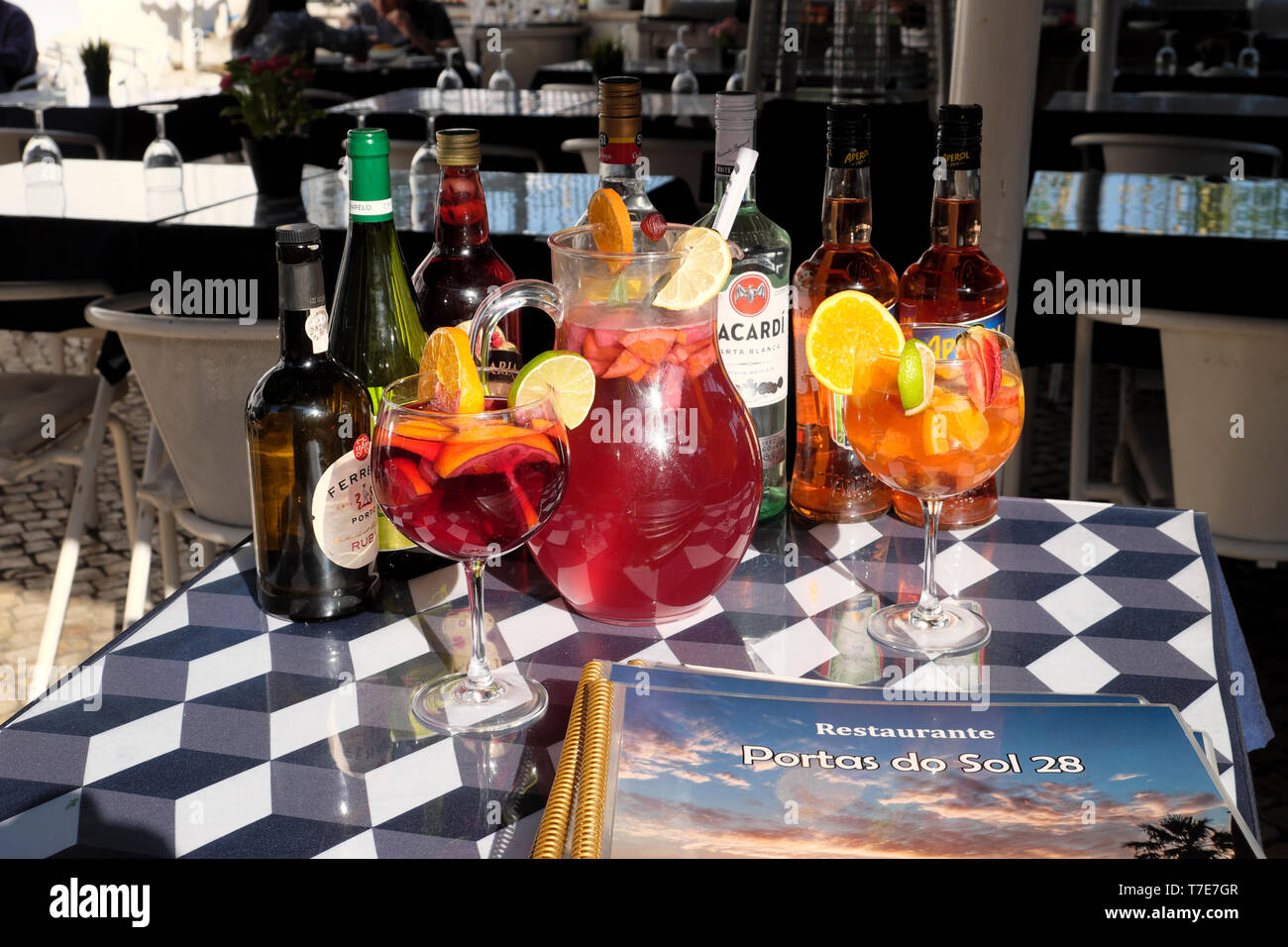 Selección de varios alcohol ron Bacardí bebidas alcohólicas en botellas, jarra y vasos con rodajas de limón en la mesa sentado en un bar de Lisboa KATHY DEWITT Foto de stock