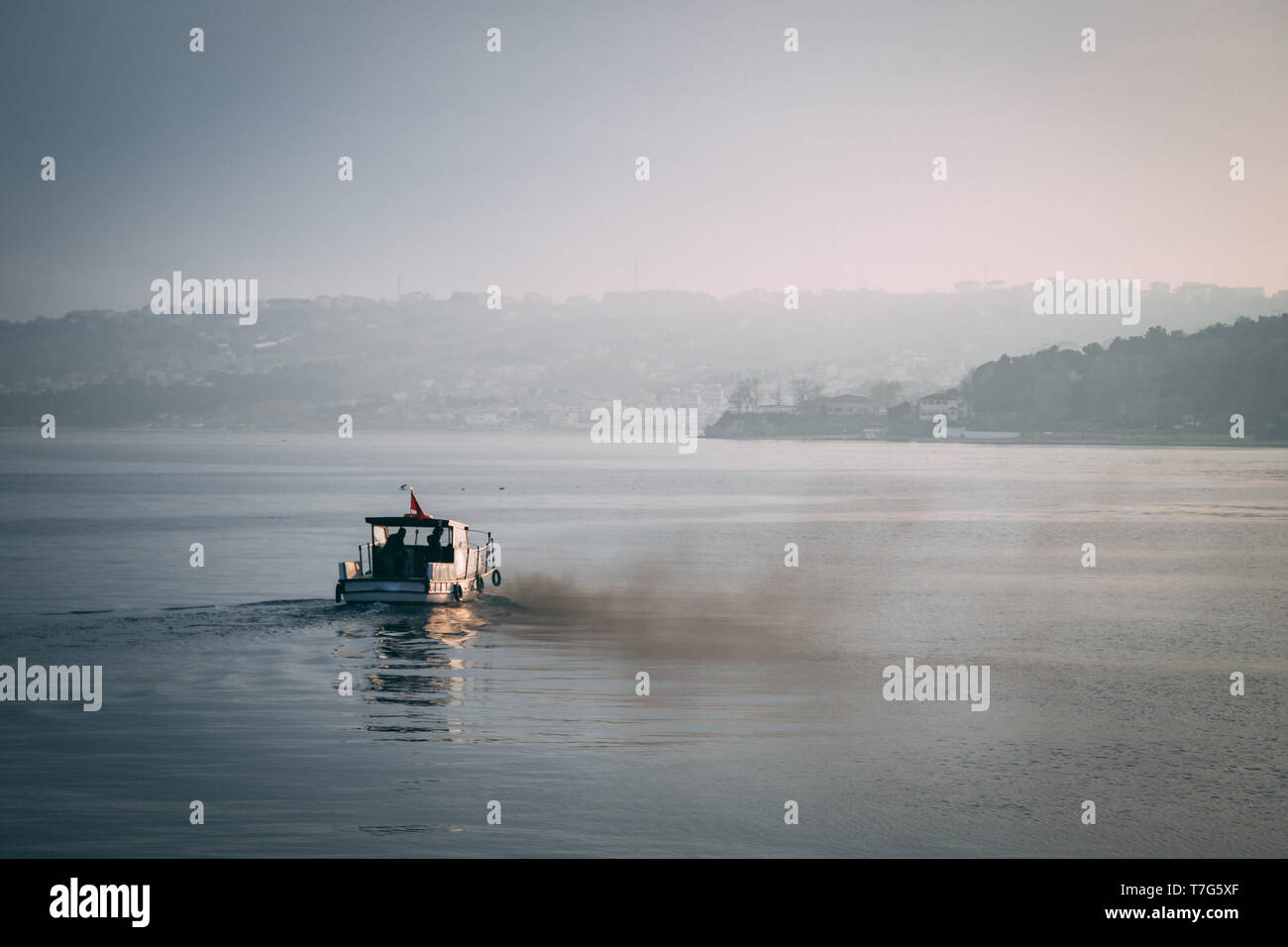 Pequeñas embarcaciones llenan el aire con humo y contaminación de su motor Foto de stock
