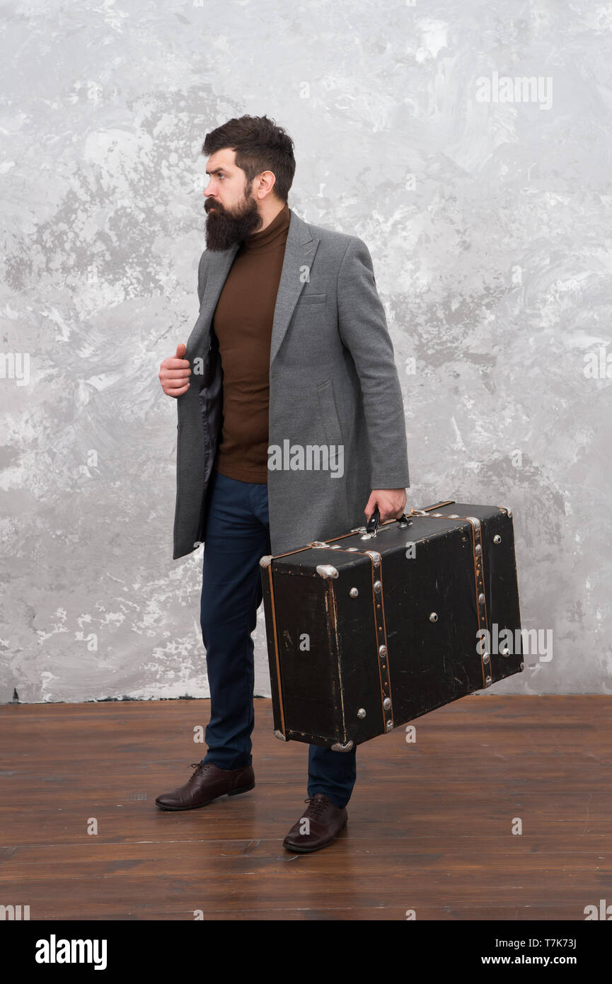 Moda Hombre con maleta de viaje. Vintage maleta de viaje. La vida moderna.  Modelo de moda masculina. Empresario maduro con barba. Fot viaje de  negocios. Estilo informal. Brutal hipster barbudo en denim