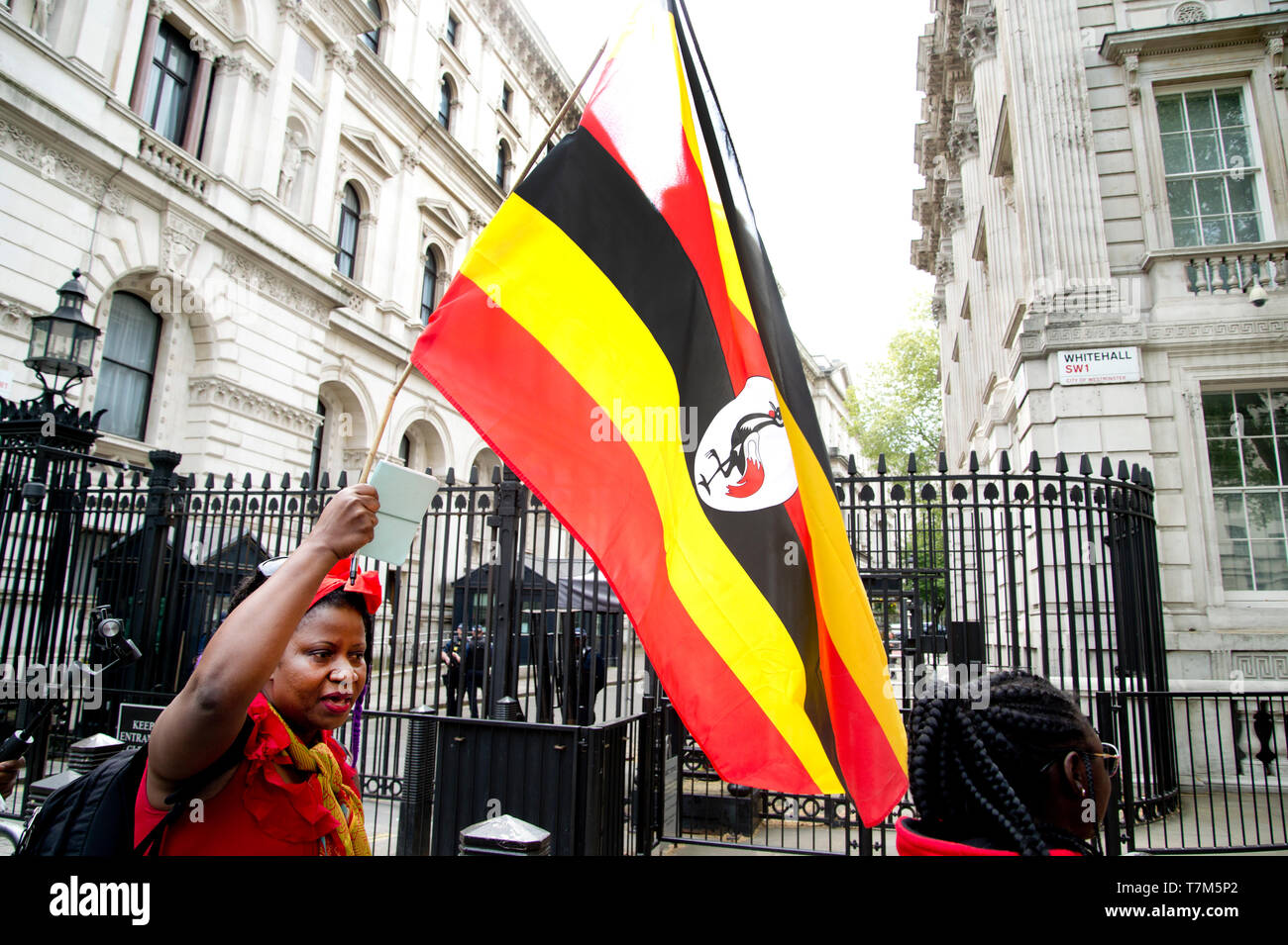 Westminster Mayo7th 2019. Los ugandeses a manifestarse contra el Gobierno del Presidente Museveni (M7). Una mujer olas un ugandés bandera delante de Downing Stre Foto de stock