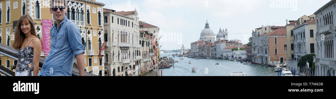 Imagen panorámica de dos turistas en un puente con vistas a la Gran Canal de Venecia Foto de stock