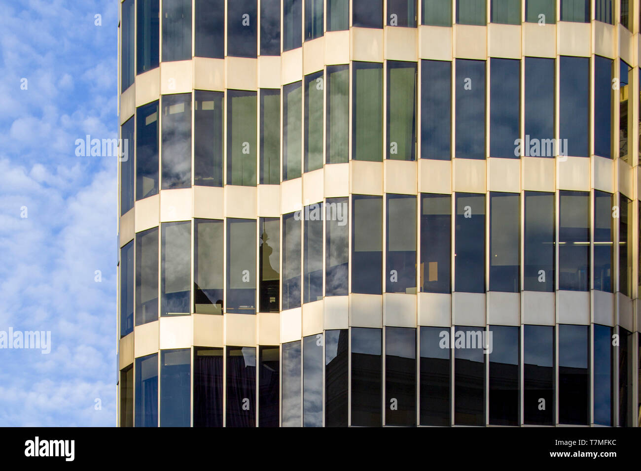 Un moderno edificio de vidrio y metal de diseño inusual, con una fachada curva. Foto de stock