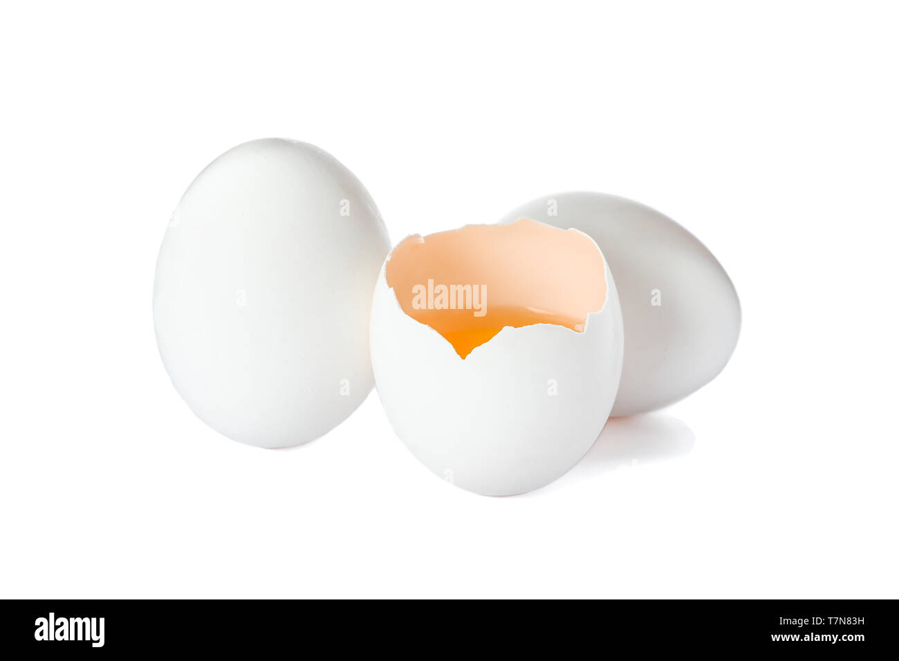 Huevos de gallina y la mitad de la yema de huevo aislado sobre fondo blanco. Foto de stock