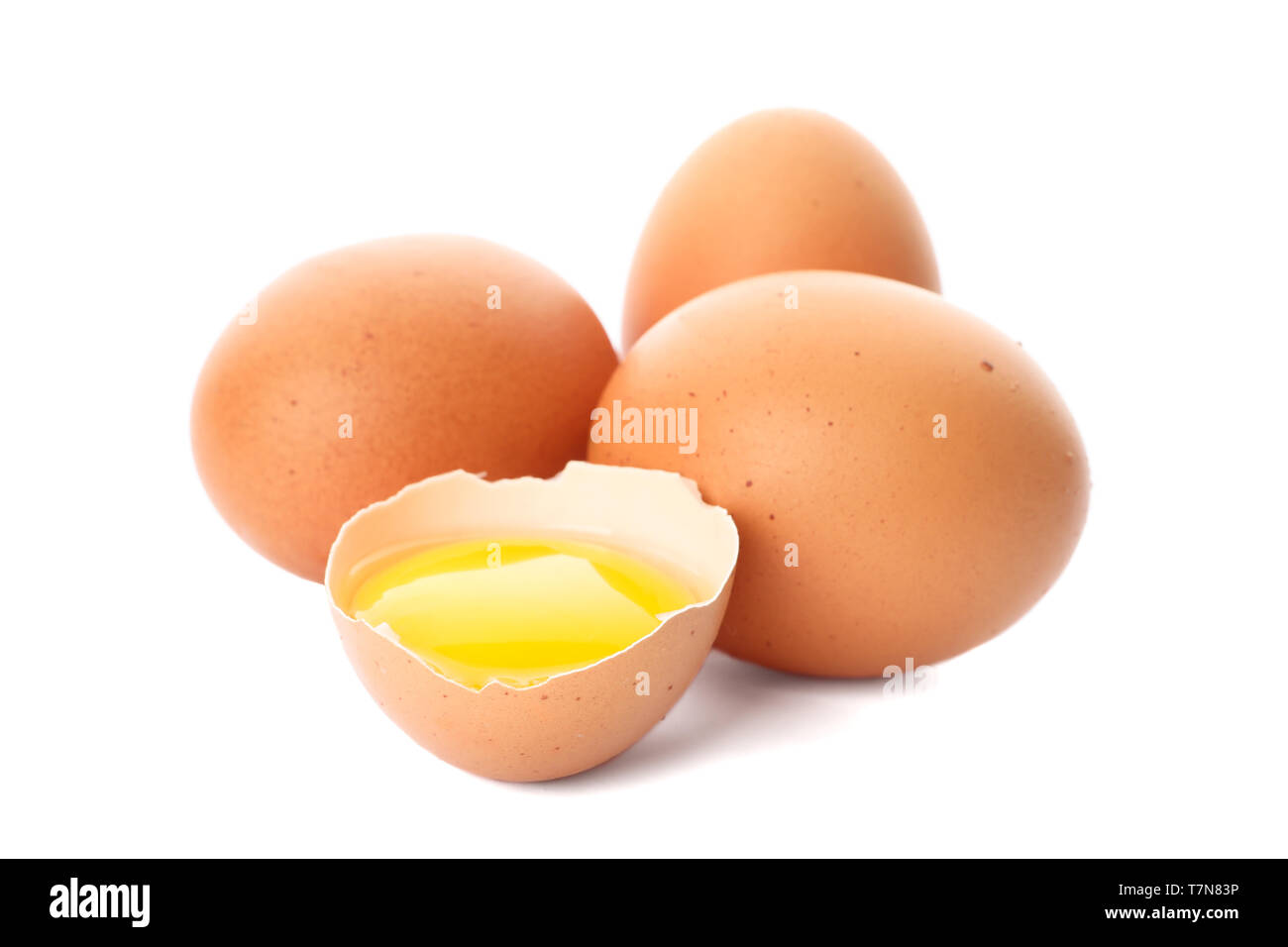 Huevos de gallina y la mitad de la yema de huevo aislado sobre fondo blanco. Foto de stock