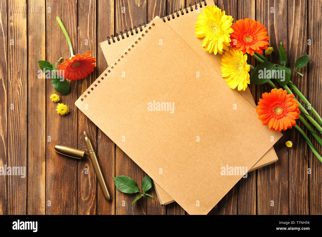 Papel en blanco y flor de gerbera en el fondo de la mesa de madera  fotografías e imágenes de alta resolución - Alamy